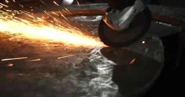 Erkek el nargile parçaları açısı öğütücü ile keser. Bir çelik inşaat alanında kıvılcım sıçraması ile kesme. Metal açılı taşlama kesim sırasında kıvılcım