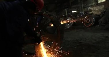 Erkek el nargile parçaları açısı öğütücü ile keser. Bir çelik inşaat alanında kıvılcım sıçraması ile kesme. Metal açılı taşlama kesim sırasında kıvılcım