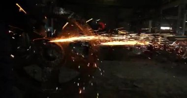 Erkek el nargile parçaları açısı öğütücü ile keser. Bir çelik inşaat alanında kıvılcım sıçraması ile kesme. Metal açılı taşlama kesim sırasında kıvılcım