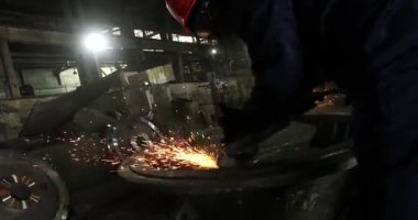 Erkek el nargile parçaları açısı öğütücü ile keser. Bir çelik inşaat alanında kıvılcım sıçraması ile kesme. Metal açılı taşlama kesim sırasında kıvılcım