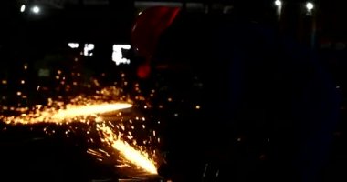 Erkek el nargile parçaları açısı öğütücü ile keser. Bir çelik inşaat alanında kıvılcım sıçraması ile kesme. Metal açılı taşlama kesim sırasında kıvılcım