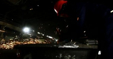 Erkek el nargile parçaları açısı öğütücü ile keser. Bir çelik inşaat alanında kıvılcım sıçraması ile kesme. Metal açılı taşlama kesim sırasında kıvılcım