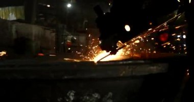 Erkek el nargile parçaları açısı öğütücü ile keser. Bir çelik inşaat alanında kıvılcım sıçraması ile kesme. Metal açılı taşlama kesim sırasında kıvılcım