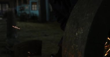 Erkek el nargile parçaları açısı öğütücü ile keser. Bir çelik inşaat alanında kıvılcım sıçraması ile kesme. Metal açılı taşlama kesim sırasında kıvılcım