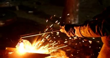 Erkek el nargile parçaları açısı öğütücü ile keser. Bir çelik inşaat alanında kıvılcım sıçraması ile kesme. Metal açılı taşlama kesim sırasında kıvılcım