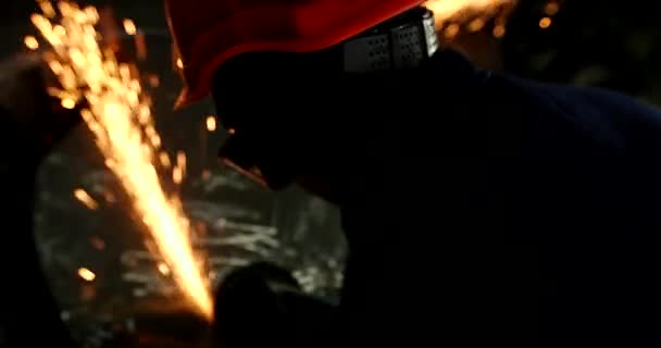 男性手用角磨机割断水管碎片 在建筑工地上切割有火花的钢 金属角磨床切割过程中的火花 — 图库视频影像