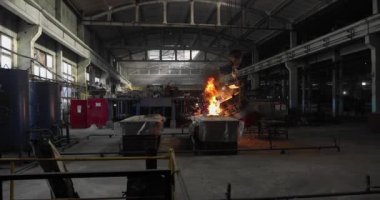 Dökümhanede çok çalışmak. Çelik fabrikasında metal eritme fırını. Erimiş metal dökümü, metalürji, çelik döküm dökümü. Çelik imalatı