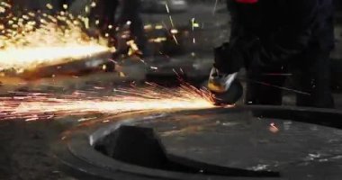 Metal açı öğütücüsünün kesilmesi sırasında kıvılcımlar. Parlayan kıvılcım bir sürü öğütücü dönen disk etrafında uçar. Pırıl pırıl bir arka plan. Metal kesim
