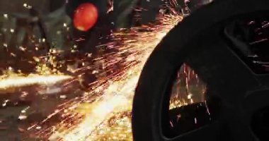 Metal açı öğütücüsünün kesilmesi sırasında kıvılcımlar. Parlayan kıvılcım bir sürü öğütücü dönen disk etrafında uçar. Pırıl pırıl bir arka plan. Metal kesim