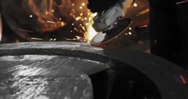 Metal açı öğütücüsünün kesilmesi sırasında kıvılcımlar. Parlayan kıvılcım bir sürü öğütücü dönen disk etrafında uçar. Pırıl pırıl bir arka plan. Metal kesim