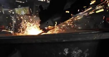 Metal açı öğütücüsünün kesilmesi sırasında kıvılcımlar. Parlayan kıvılcım bir sürü öğütücü dönen disk etrafında uçar. Pırıl pırıl bir arka plan. Metal kesim