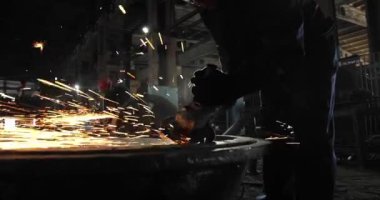 Metal açı öğütücüsünün kesilmesi sırasında kıvılcımlar. Parlayan kıvılcım bir sürü öğütücü dönen disk etrafında uçar. Pırıl pırıl bir arka plan. Metal kesim