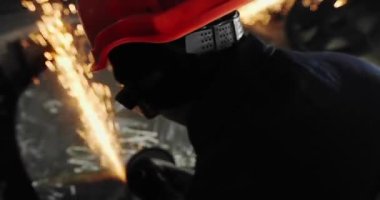 Metal açı öğütücüsünün kesilmesi sırasında kıvılcımlar. Parlayan kıvılcım bir sürü öğütücü dönen disk etrafında uçar. Pırıl pırıl bir arka plan. Metal kesim