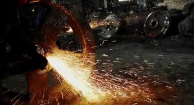 Metal açı öğütücüsünün kesilmesi sırasında kıvılcımlar. Parlayan kıvılcım bir sürü öğütücü dönen disk etrafında uçar. Pırıl pırıl bir arka plan. Metal kesim