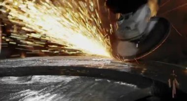 Metal açı öğütücüsünün kesilmesi sırasında kıvılcımlar. Parlayan kıvılcım bir sürü öğütücü dönen disk etrafında uçar. Pırıl pırıl bir arka plan. Metal kesim