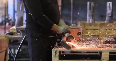 Açı öğütücüsüyle metal keserken kıvılcımlar çıkıyor..