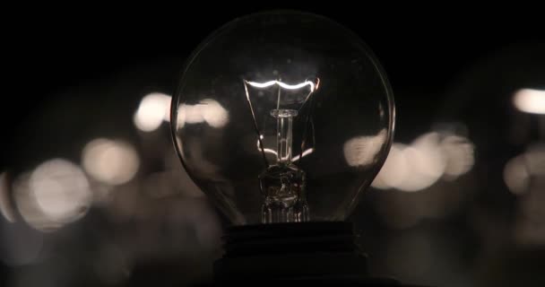 La lampe à incandescence avec un filament de tungstène vacille sur le fil. La lumière clignote. La lumière d'une ampoule. Gros plan de l'ampoule .