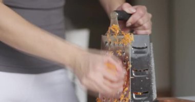 Bir parça havucu daha küçük parçalara ayırmaya çok yaklaştık. Kadın eli, tahta bir tahtanın üzerinde havuç dilimliyor..