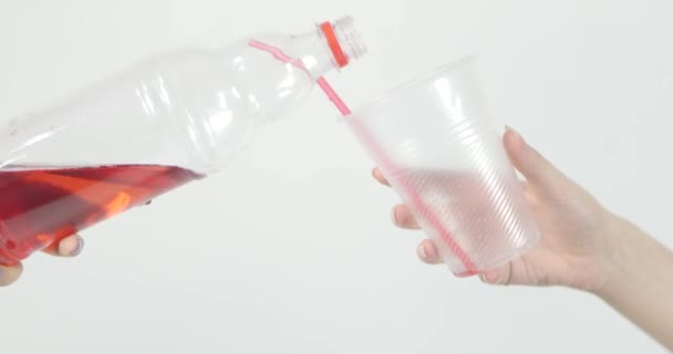 Bir Kadın Plastik Şişeden Kırmızı Meyve Suyunu Bardağa Dolduruyor Beyaz — Stok video