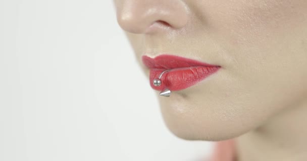 孤立した白い背景に美しい女性の赤いセクシーな唇を閉じます 女性手保持チューブ赤と白のスタジオの背景 — ストック動画