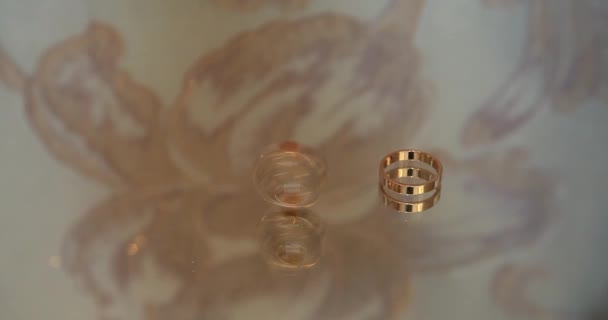结婚戒指不是明亮光芒下的一张深色桌子 两个结婚戒指都有无限的标志 爱的概念 键盘上的结婚戒指 — 图库视频影像