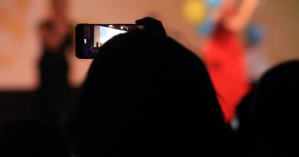 Πλήθος πάρτι στο υπαίθριο ροκ συναυλία. Νεαρή γυναίκα να στέκεται μέσα στο πλήθος που κατέχει το smartphone στα χέρια γυρίσματα βίντεο βλέπουν ψηφιακή οθόνη — Αρχείο Βίντεο