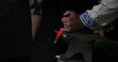 Demirci metal dövmek için çekiç kullanıyor.