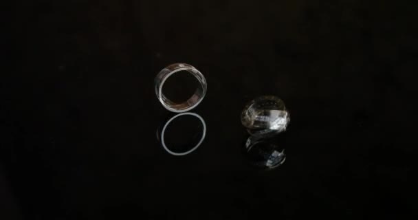 Bagues de fiançailles en or sur fond noir. Anneaux de mariage. Deux splendides alliances le jour du mariage. Deux alliances sur la table .