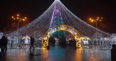 Ukrayna, Poltava, 25 Aralık 2019. Noel 'den önceki gece. Ana pazar meydanında duran parlak noel ağacı, kış tatilleri, insanların hoşuna gidiyor.