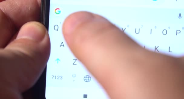 男はスマートフォンを使ってSmsメッセージを書きます 携帯電話でテキストメッセージを入力し 自宅で携帯電話で男性のテキストメッセージ 画面がぼやけている — ストック動画