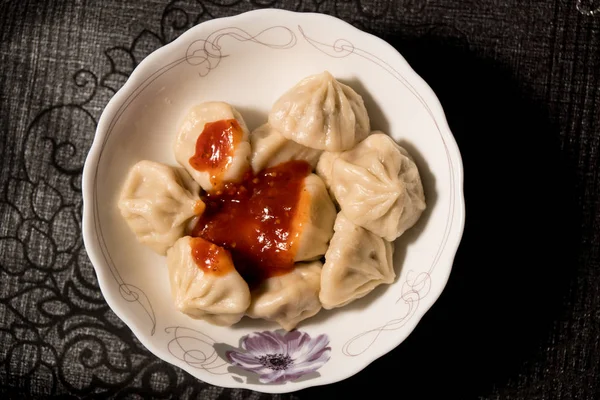 Close-up van draaiende plaat van heerlijke khinkali dumplings gekruid met Chili peper — Stockfoto