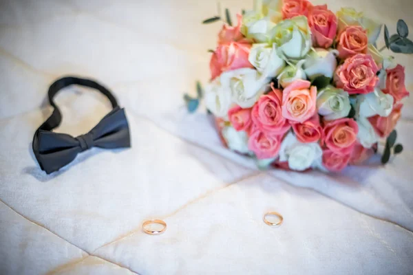 Detailní záběr elegantní stylové hnědé mužské doplňky izolované na bílém dřevěném pozadí. Horní pohled na motýlka, opasek, boty, květinové květy, zlaté prsteny. Příprava na svatební koncept. Vodorovná fotografie — Stock fotografie