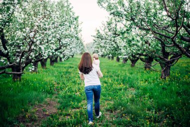 Beyaz spirea çiçekleriyle çiçek açan çalıların arkasında poz veren hippi bir kadın. Çiçek kıyafetleri içinde saçlarını sallayan kız. Metin için boşluk. Bahar mevsimi