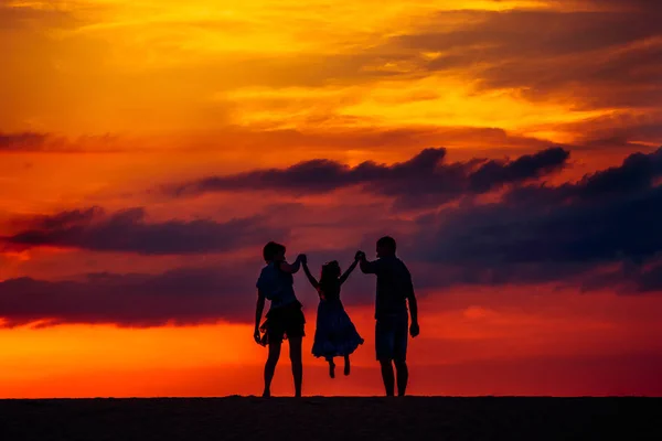 Gün batımında yaz çayır üzerinde mutlu bir aile — Stok fotoğraf