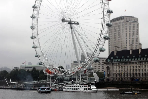 Ein Blick auf ein Riesenrad, während das Licht zu verblassen beginnt und die Lichter am Rad prominenter werden — Stockfoto