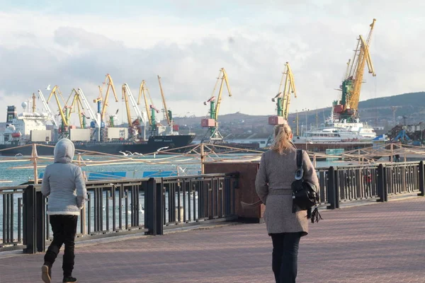 El sol invernal sobre Robber Bay y Cape Kapchik en Crimea. Siluetas de personas en el Sendero Golitsyn en el pueblo turístico del Nuevo Mundo. Día nublado a principios de primavera — Foto de Stock