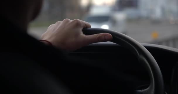高速道路を走行する車の内部から車のステアリングホイールを保持する人の手のクローズアップ. — ストック動画