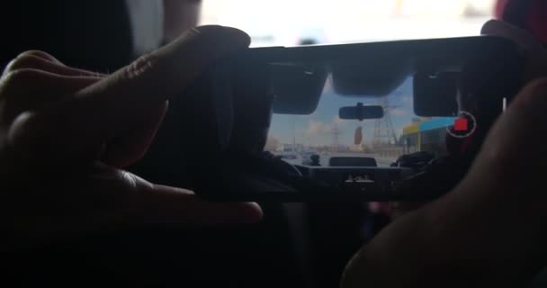 Een man neemt een video op met haar mobiele telefoon tijdens een autorit. Zicht op de weg door de voorruit. — Stockvideo