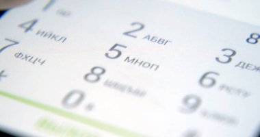 Onun akıllı telefon ekranına bakarak bir bankta oturan genç yakışıklı adam. Adam telefonda mesajı okur. Yazışma Smartphone cep telefonu ile açık.