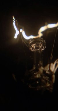 Siyah bir arka planda, parlak iplik tungsten lambaları