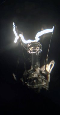 Siyah bir arka planda, parlak iplik tungsten lambaları