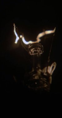 Siyah bir arka planda, parlak iplik tungsten lambaları