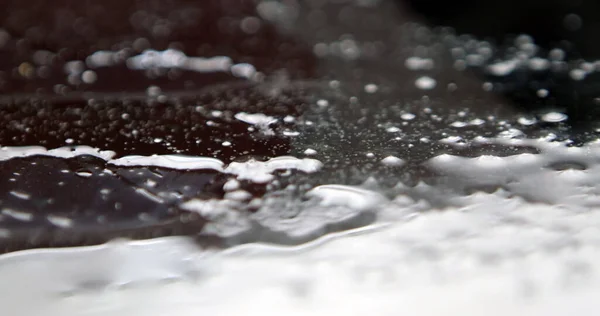 黒の背景には 水が飛び散るの凍結ショット — ストック写真