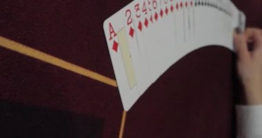 Telefonlar ve tabletler için dikey video. Poker dağıtıcısı tam deste iskambil kağıtlarını karıştırıyor