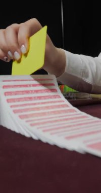 Telefonlar ve tabletler için dikey video. Poker dağıtıcısı tam deste iskambil kağıtlarını karıştırıyor