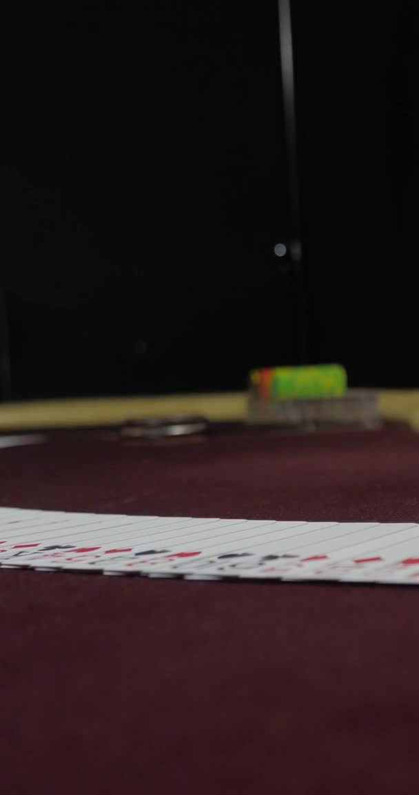 Vidéo verticale pour téléphones et tablettes. Concessionnaire assis dans un casino à table tout en tenant et distribuant des cartes — Video