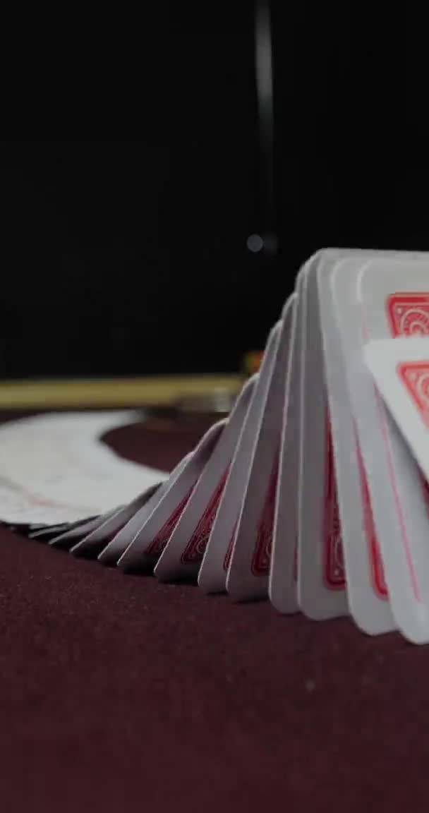 Вертикальне відео для телефонів і планшетів. Дилер покеру перетасовує повну колоду гральних карт — стокове відео