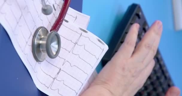 Medicinsk hjärtmonitorremsa. Hjärtmonitor utskrift elektrokardiogram diagnostiska resultat. Närbild av ecg utskrift. — Stockvideo