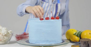 Pastayı dekore eden kadın şef, beyaz arka planda izole edilmiş.