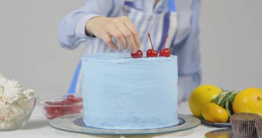 Pastayı dekore eden kadın şef, beyaz arka planda izole edilmiş.